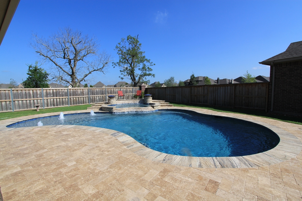 Backyard pool with elegant fountains and seating area