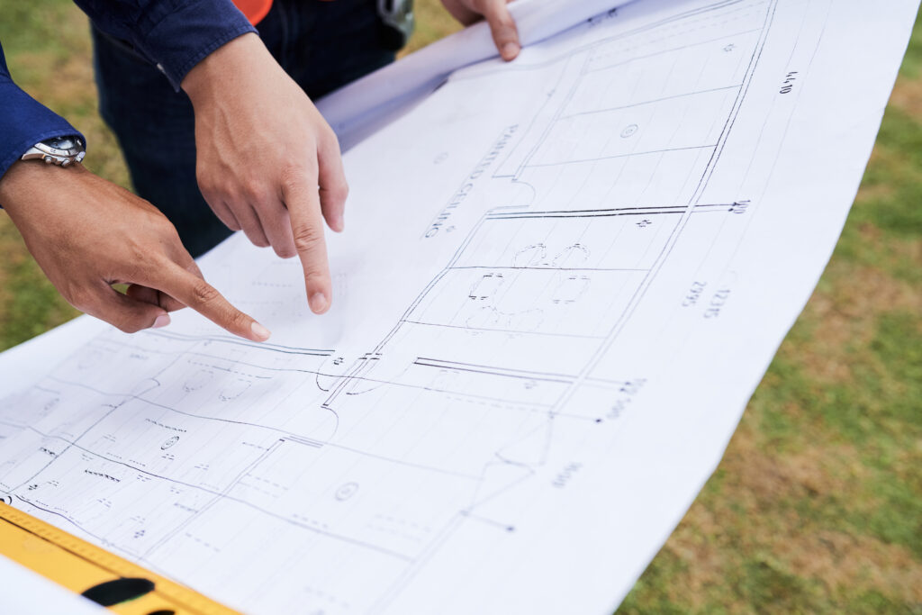 Engineers reviewing design plans for a backyard lazy river pool layout